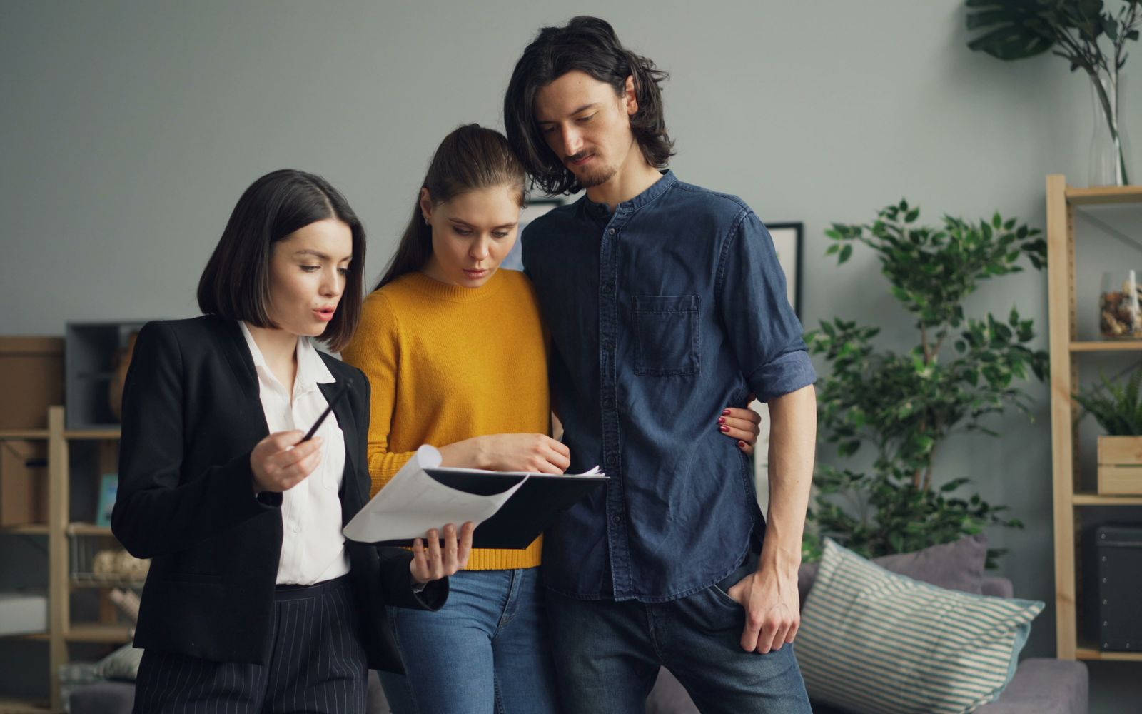 A couple discussing home-buying plans with a real estate professional