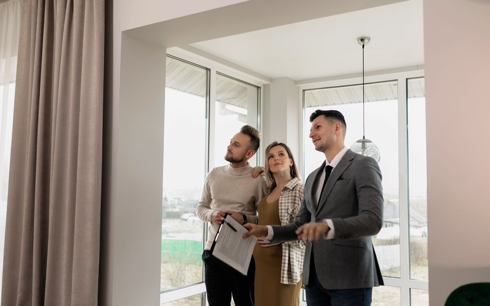 A couple touring a bright modern home with a real estate professional