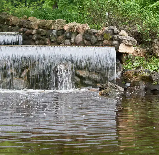 Small waterfall flowing over rocks in a wooded area